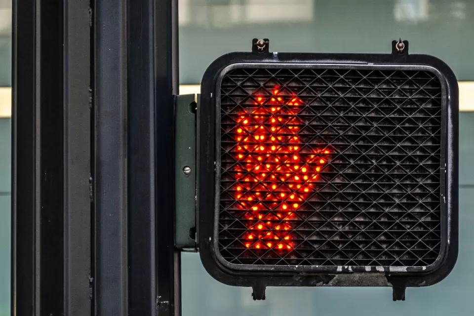 Red hand lit up as "don't walk" pedestrian signal.